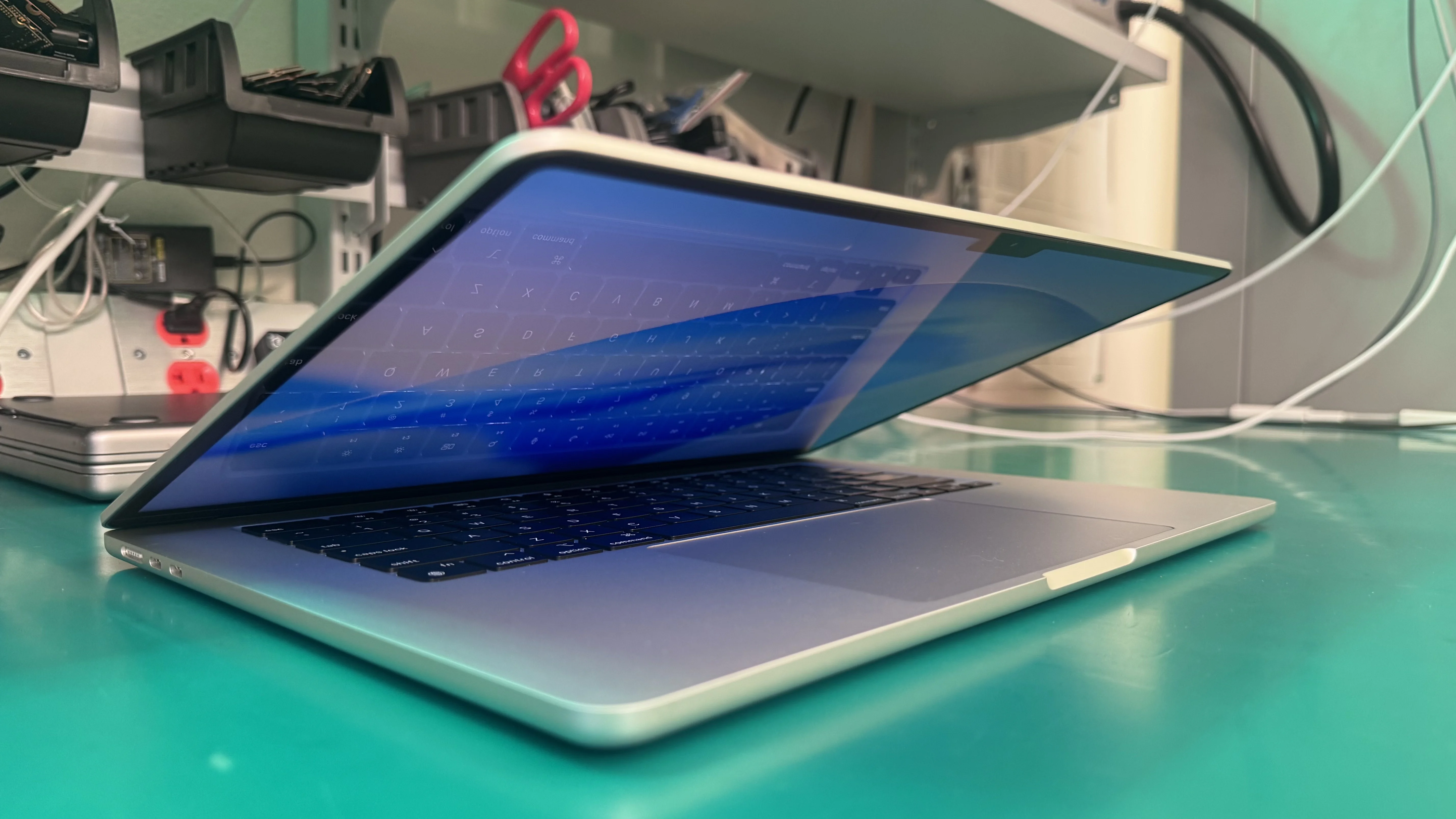 MacBook Pro open on WarriorMac repair workbench showing Retina display in Tampa